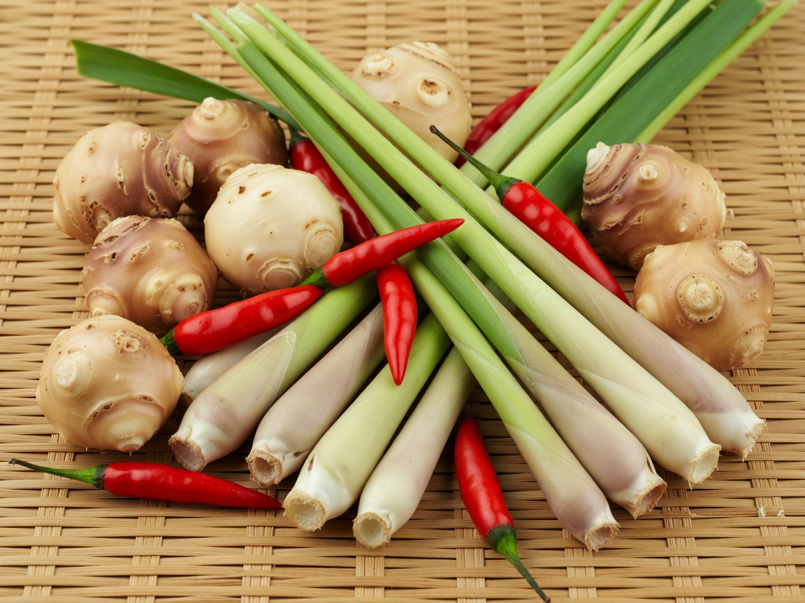 Fresh Galangal, Lemongrass, and Red Chilis laid on bamboo mat